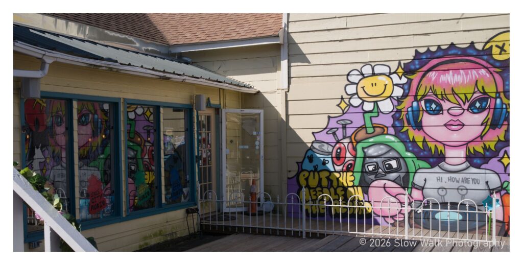 Colorful street mural of a pink-haired character wearing headphones in Old Town Spring, Texas